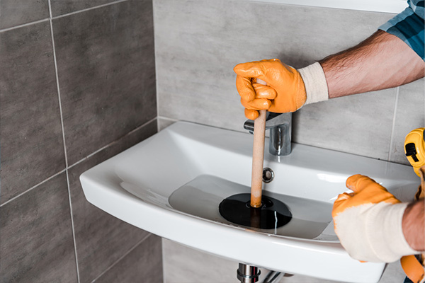  Arm holding plunger in clogged sink